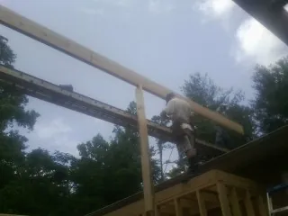 Carpenter setting a ridge beam over a new addition frame — Ice Dam Removal by Roofing Brothers in Schenectady