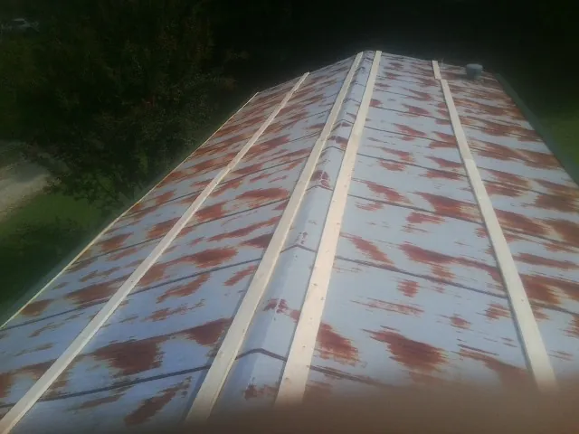 Rusted metal roof panels with new wood purlins before replacement — Storm Damage Roof Repair in Schenectady by Roofing Brothers
