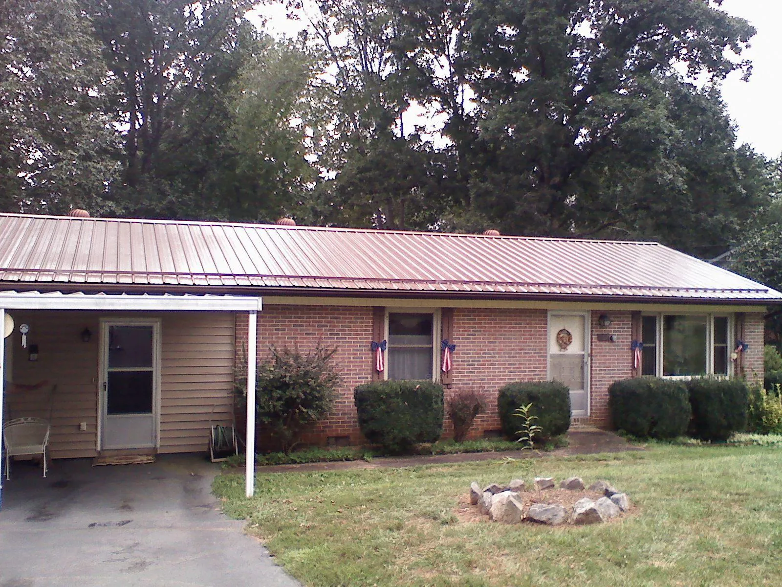 Bronze metal roof and carport on a brick ranch home — Roof Repair work by our crew in Schenectady